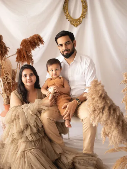 A formal family portrait with a boho twist. The mother's beautiful gown and the earthy tones of the set create a unique and stylish look.