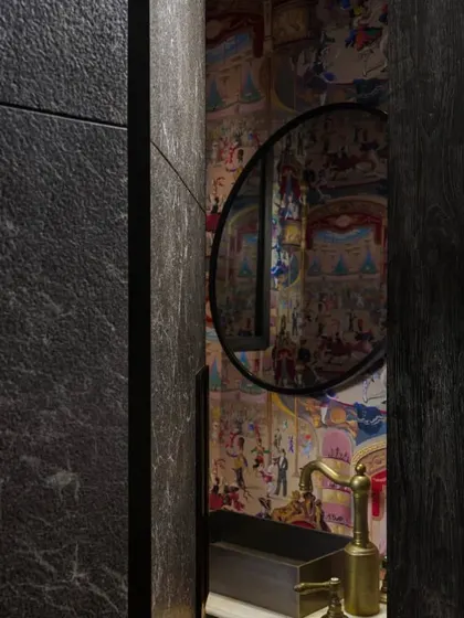 A peek into the powder room through a custom-designed stone door. This detail shows our commitment to creating unique transitions between spaces, where even a doorway becomes a moment of architectural interest.