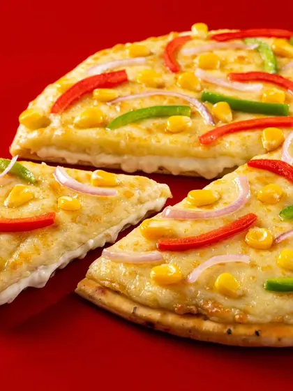 A vibrant veggie pizza from Ovenstory, topped with corn, peppers, and onions. The bright colours and clean background make this image pop on any digital menu or food delivery platform.
