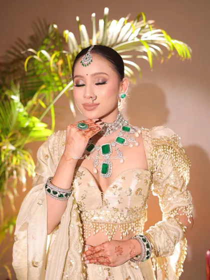 A close-up of the soft glam morning bridal makeup. I focused on creating luminous skin and defining her eyes, complemented by stunning emerald and diamond jewelry.