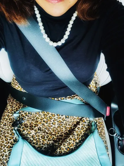 A detail shot from the car, showing the leopard print skirt and black top, emphasizing the textures and accessories.