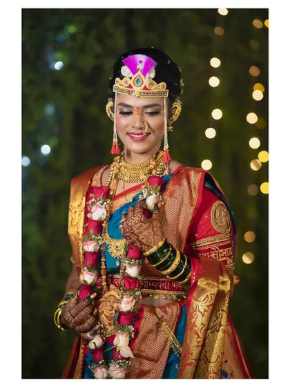 A portrait of the bride holding her garland. Her traditional Maharashtrian bridal attire, including the mundavalya and nath, is beautifully showcased.