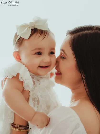 A close-up of a mother and her smiling baby girl, their faces close together. This shot perfectly captures their loving bond and shared happiness.