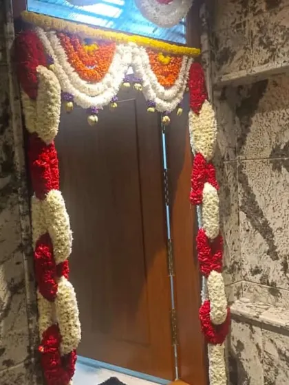 A door decorated with garlands of jasmine and red flowers. This is a classic and fragrant choice for any festive occasion at home.