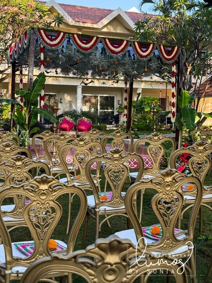 A view of the wedding seating arrangement, with ornate gold chairs leading up to the traditional mandap, ready for the ceremony to begin.