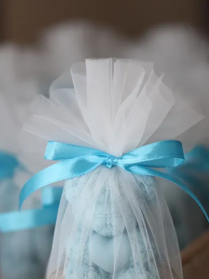 A close-up of the delicate net packaging for the Rose Bear candle favors.