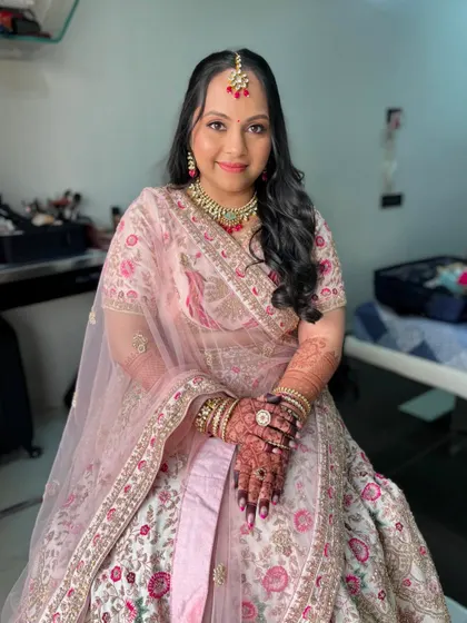 Shimmery eyes and delicately blushed cheeks create a moment of undeniable beauty for this bride in her pastel lehenga.