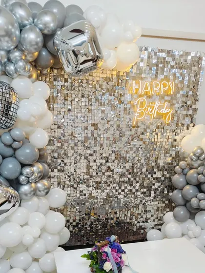 A close-up of the silver disco party theme. The shimmer wall is framed by a grey, white, and chrome balloon arch with disco ball accents.