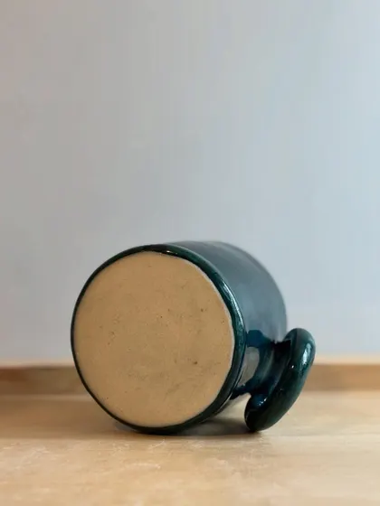 The bottom of the Forest Green mug, showing the unglazed base that contrasts beautifully with the glossy finish.