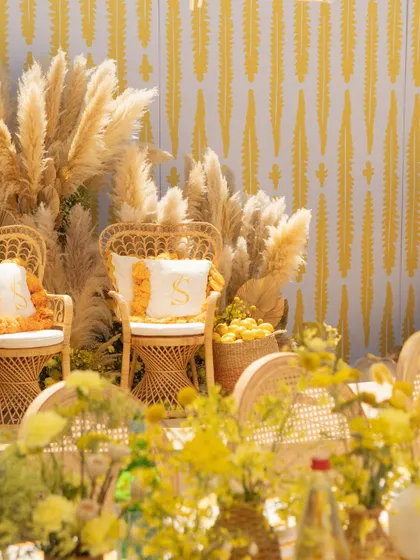 Another angle of the couple's seating, highlighting the personalized details and the beautiful texture of the pampas grass backdrop.