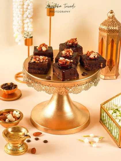 A wider shot of the chocolate brownies on a cake stand, styled with traditional diyas and lanterns for a festive feel.