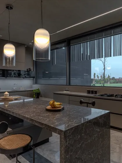 Expansive windows in this farmhouse kitchen draw in natural light and offer views of the surrounding landscape, making the space feel open and connected to the outdoors.