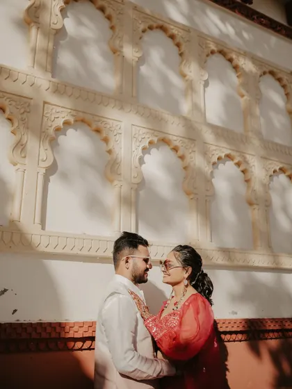 A close-up shot filled with affection. The couple gazes at each other, their proximity creating an intimate and romantic mood, perfectly framed by the architectural details behind them.