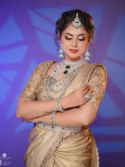 The combination of a classic updo, smokey eyes, and layered jewelry creates a sophisticated and modern bridal reception look.