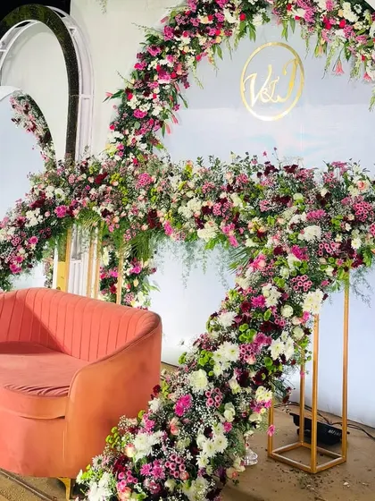 A side view of a magnificent floral arch, showcasing the density and variety of flowers used to create this stunning reception backdrop.