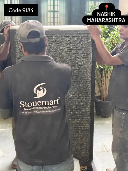 My team carefully maneuvers the 5-foot ribbed granite waterfall panel during the packing process.