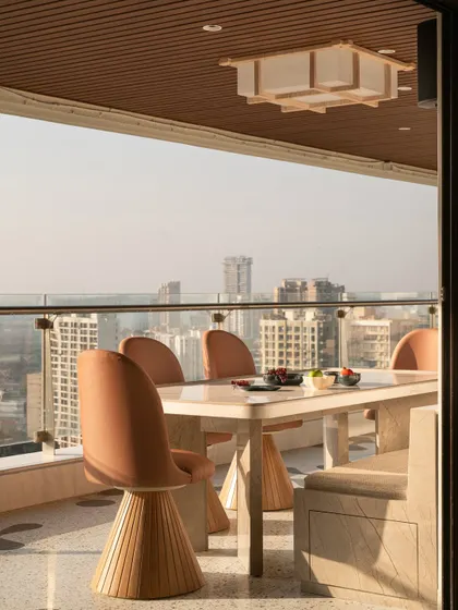 The dining area on the Gingham Dreams terrace, with modern swivel chairs and a Japanese-style lightbox, offering a sophisticated spot for al fresco meals.