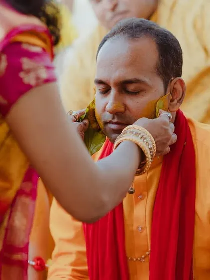 A close-up of the groom receiving the Haldi application, a moment of quiet tradition.