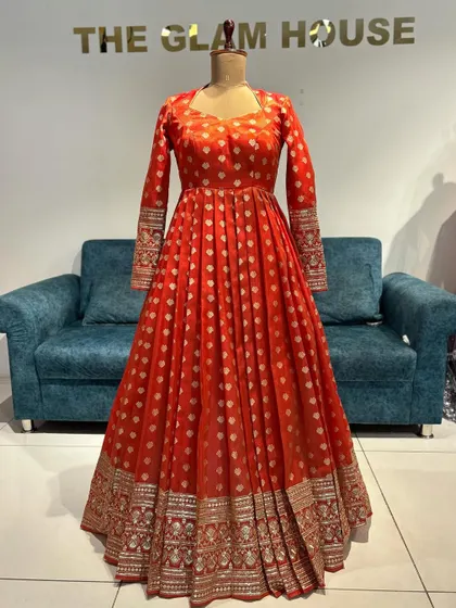 The front view of the red Banarasi Anarkali gown, with its rich fabric and elegant full sleeves.