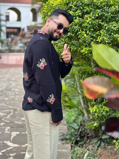 A playful pose showing off my embroidered shirt. It's all about having a cool, approachable vibe.