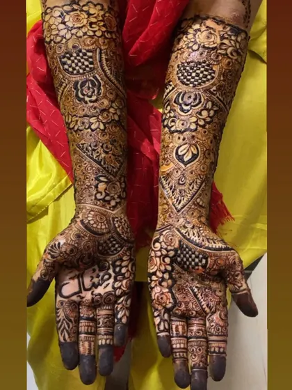 A classic example of full bridal coverage. This design features a beautiful blend of checkerboard patterns, floral motifs, and paisleys, creating a rich and textured look perfect for a traditional wedding.