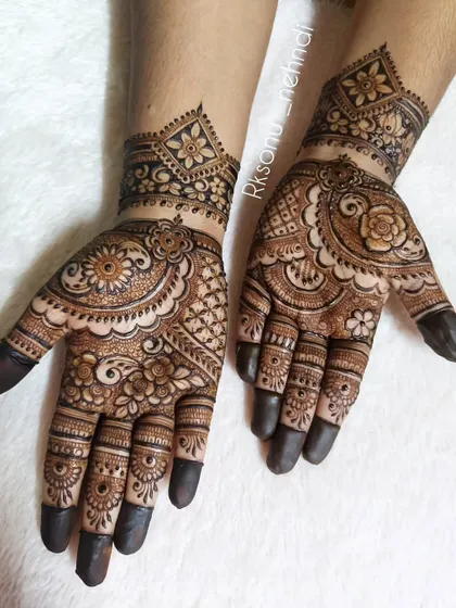 An intricate and full-coverage design perfect for a festive occasion. The pattern combines floral mandalas with detailed work on the fingers and a geometric wristband.