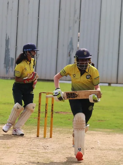Two batters complete a quick single, showcasing agility and communication between the wickets.