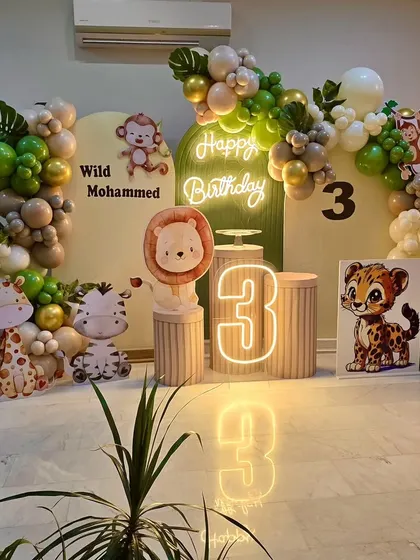 Another angle of the stylish 'Wild Mohammed' jungle theme party decor, showing the reflection of the neon sign and marquee number on the glossy floor.