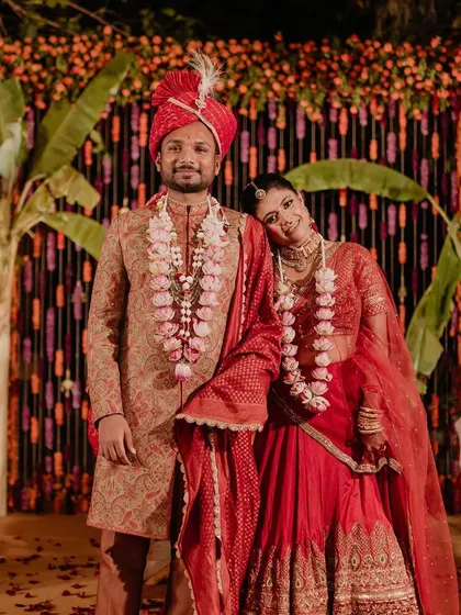 The first official portrait as husband and wife. The couple stands before a backdrop of colorful tuberose strings and banana leaves, a beautiful fusion of textures and traditions that framed their moment perfectly.