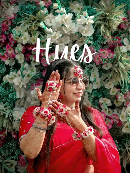 A fun and stylish portrait of Ahana at her Haldi, wearing sunglasses and showing off her beautiful floral hand jewelry.