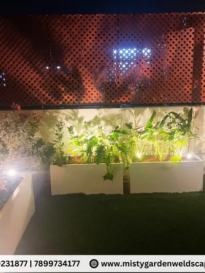 A detailed shot of the illuminated planters against a PVC lattice screen, showcasing how we use lighting and privacy screens to enhance the ambiance of a terrace garden.