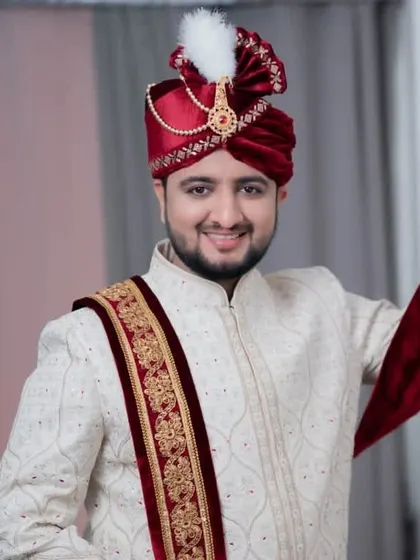 The groom looking cheerful and ready, with his turban on. The complete look is traditional, regal, and perfect for a grand wedding.