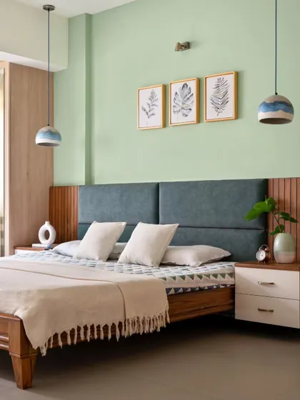 A closer look at the guest bedroom's details, including the foliage art, cement ombre pendant lights, and the mix of textures in the headboard and side table.