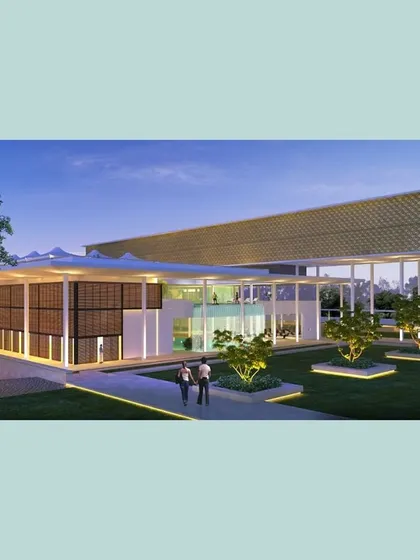 An evening view of the Pavilion, where a floating volume on the upper level creates a counterpoint to the open ground floor. This juxtaposition of solid and void defines the building's architectural character.