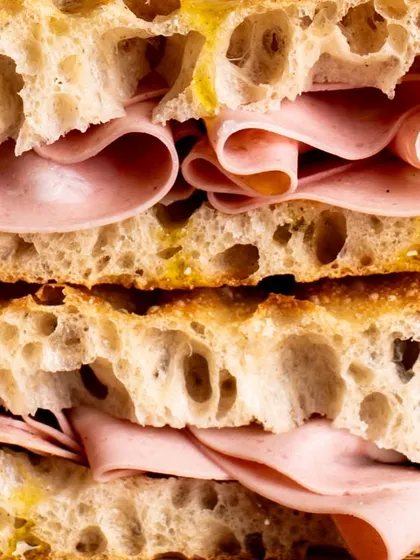Another macro shot, this time of a mortadella sandwich. The focus is on the delicate folds of the meat and the texture of the bread.