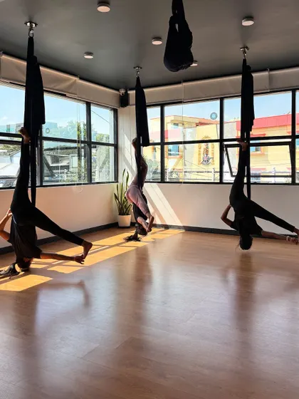 An advanced split variation performed while inverted in the hammock, highlighting incredible flexibility.