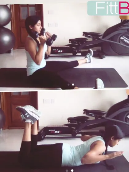 This shows how versatile training can be, with effective exercises you can do in a home gym setup. This client is performing a seated dumbbell press and a back extension on the mat.