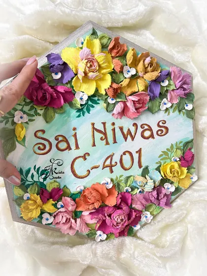 Holding the hexagonal "Sai Niwas" nameplate to show its size and the beautiful 3D effect of the flowers.