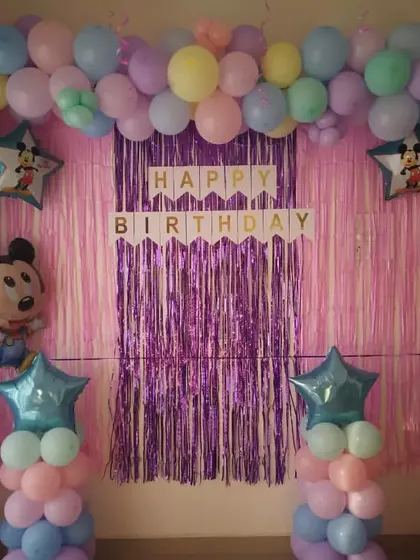A pastel balloon theme for a 3rd birthday, featuring a Mickey Mouse foil balloon. The soft, multi-colored balloons create a gentle and cheerful atmosphere.