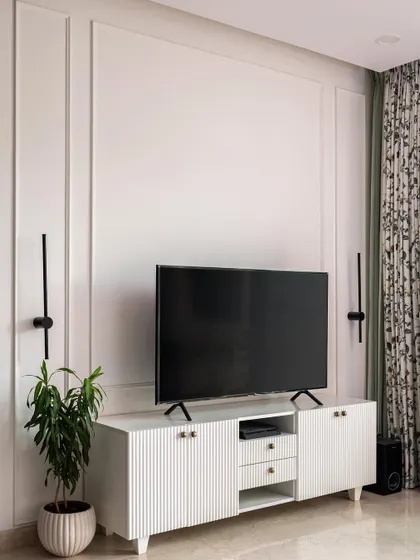 A favorite shot from "The White Oasis" project. This Scandinavian-style living room features a clean, white TV unit with fluted doors, simple wall molding, and minimalist black wall sconces for a look that is both elegant and serene.