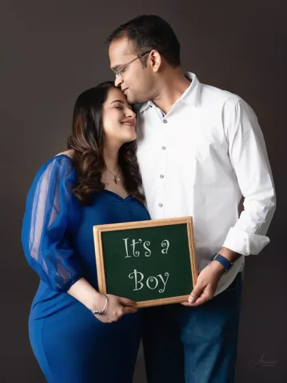 Sharing the happy news. This couple's portrait with an "It's a Boy" sign is a joyful and direct way to celebrate the new addition to their family.