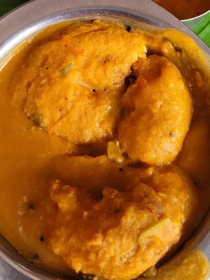 A close-up of our vadas soaked in rich, flavorful sambar. You can see how the vada absorbs the sambar, making every spoonful a burst of taste and texture.