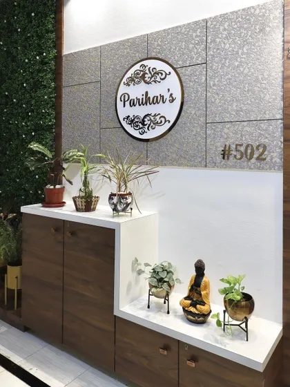 A detailed shot of the entrance shoe cabinet and display area. The design provides practical storage while also offering space for plants and decorative items, making the foyer feel lived-in and welcoming.