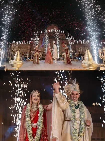 The couple raises their hands in celebration after their Varmala, framed by a dazzling display of ground and aerial fireworks.