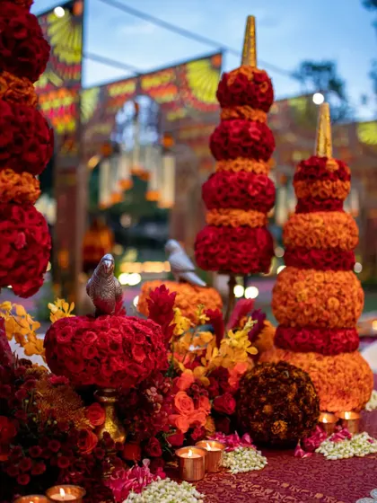 A detail from the tablescape, where small bird figurines are perched atop the floral sculptures, adding a touch of life and symbolism to the design.