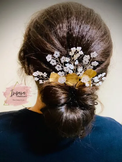 A chic and simple low bun, decorated with a delicate, sparkling hair accessory. This is a perfect hairstyle for a modern, minimalist look at a reception or party.