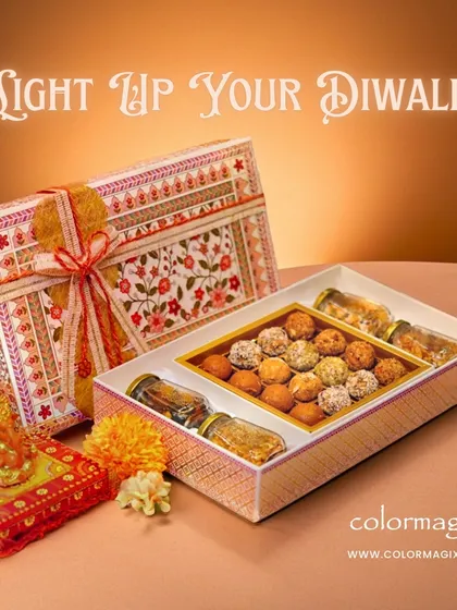 "Light Up Your Diwali" with our exquisite gift hampers. This image showcases a complete set with a box of laddoos, jars of nuts, and a small Ganpati idol for blessings.