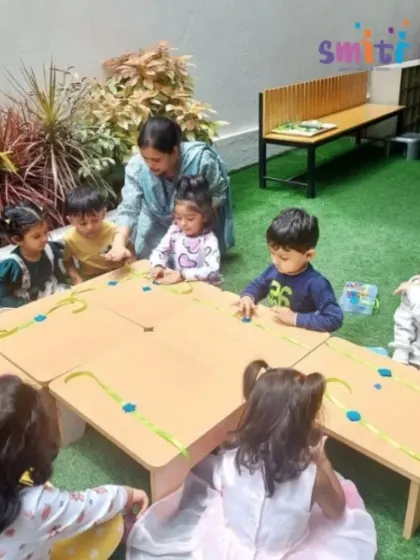 A teacher guides a group of children as they assemble their Rakhis. This collaborative craft session is filled with creativity and the spirit of the festival.