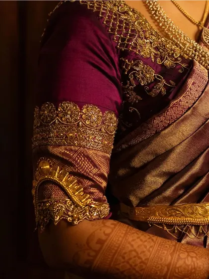 A closer look at the exquisite artwork on a bride's purple Muhurtham blouse, showcasing the armlet-style embroidery.