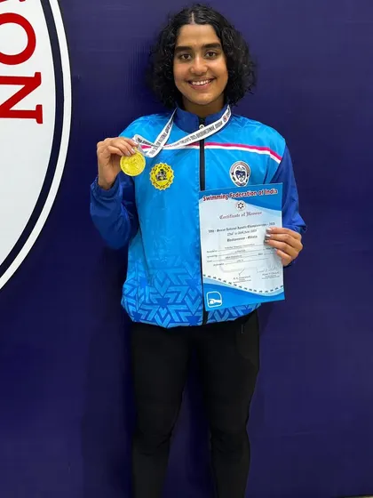 Vihitha Nayana proudly displaying her gold medal for a clean sweep in backstroke events.